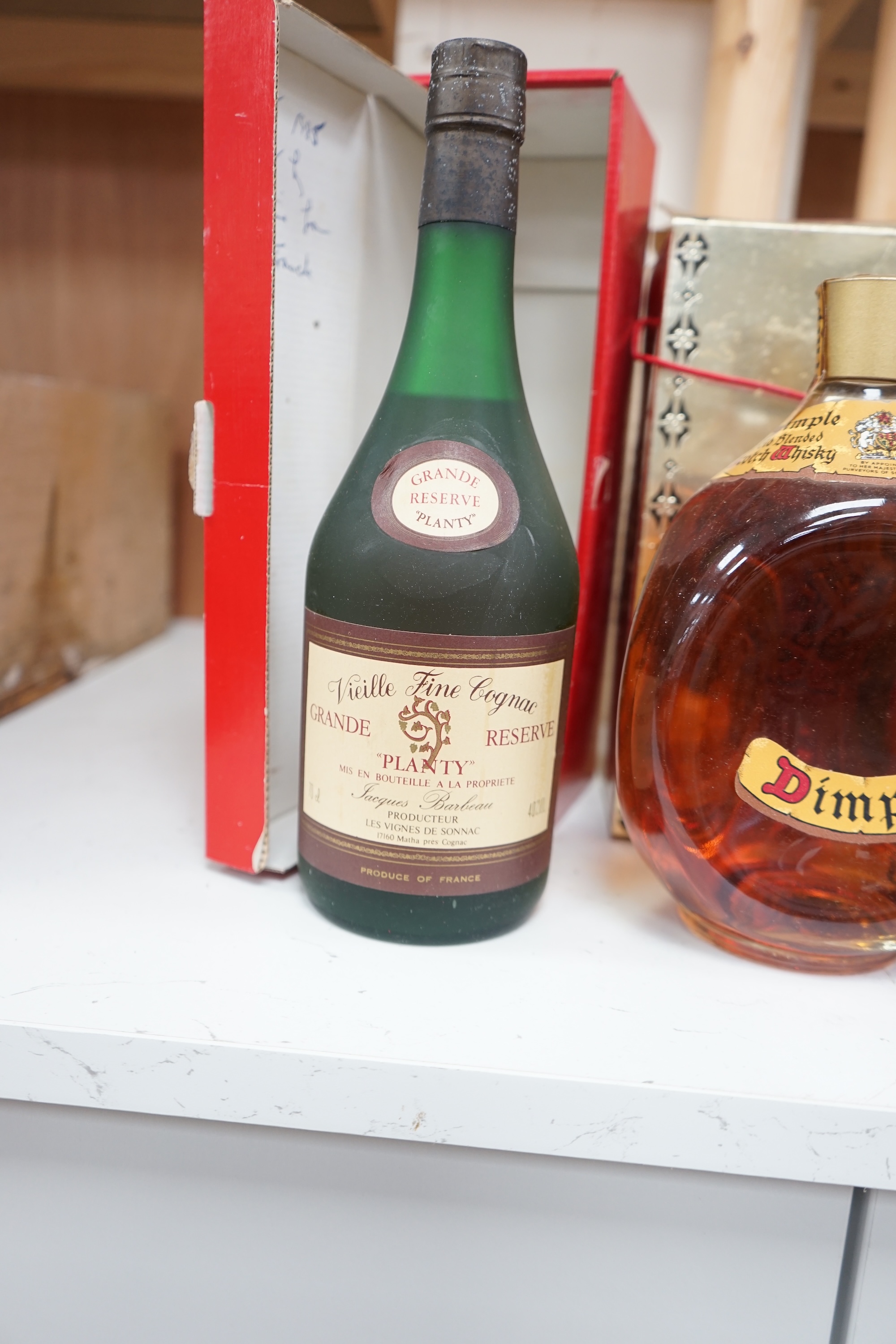 Four bottles of various alcohols comprising a bottle of 50cl Hennessey Fine Champagne Cognac, Planty Fine Cognac, Dimple Scotch Whisky and Glocken Apfel. Condition - fair, storage history unknown